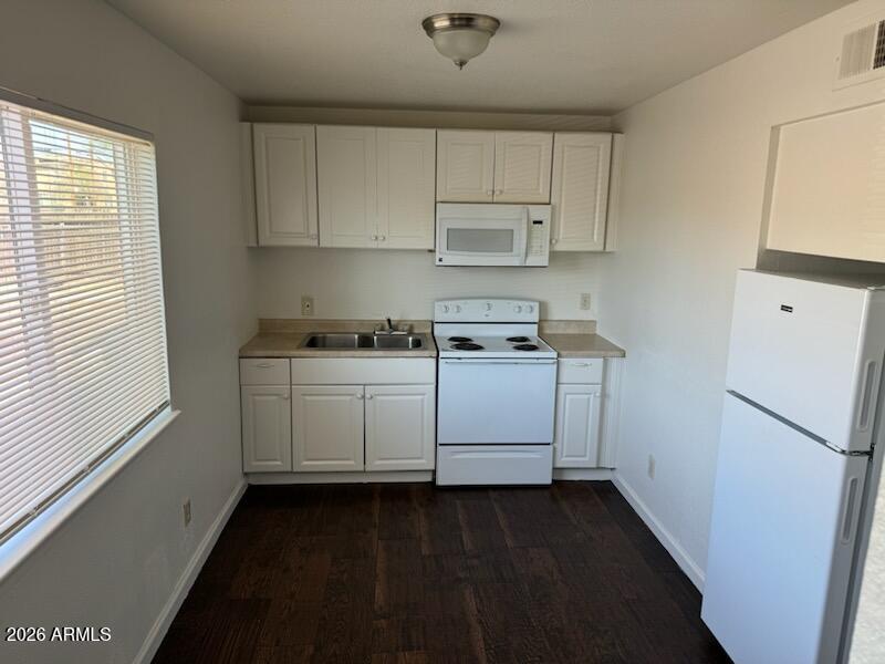1319 West Vogel Avenue, Unit 3 Phoenix, AZ 85021 - Photo 1 of 5 a kitchen with white cabinets and white appliances