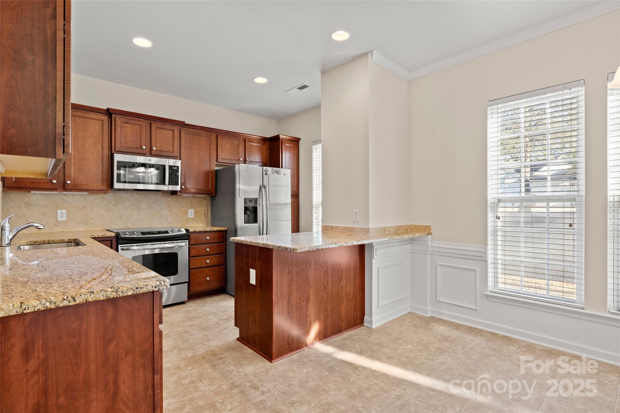 3012 Edisto Way Indian Land, SC 29707 - Photo 11 of 44 a kitchen with stainless steel appliances granite countertop wooden cabinets a stove a sink and a window