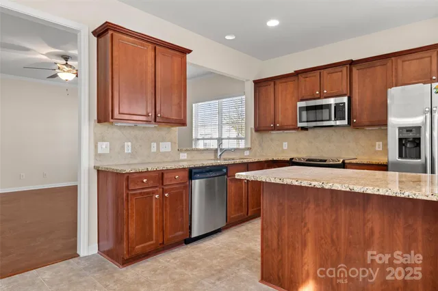 a kitchen with stainless steel appliances granite countertop a sink stove and microwave