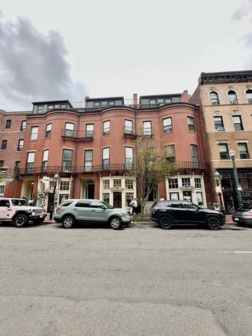 a buildings with cars parked in front of it