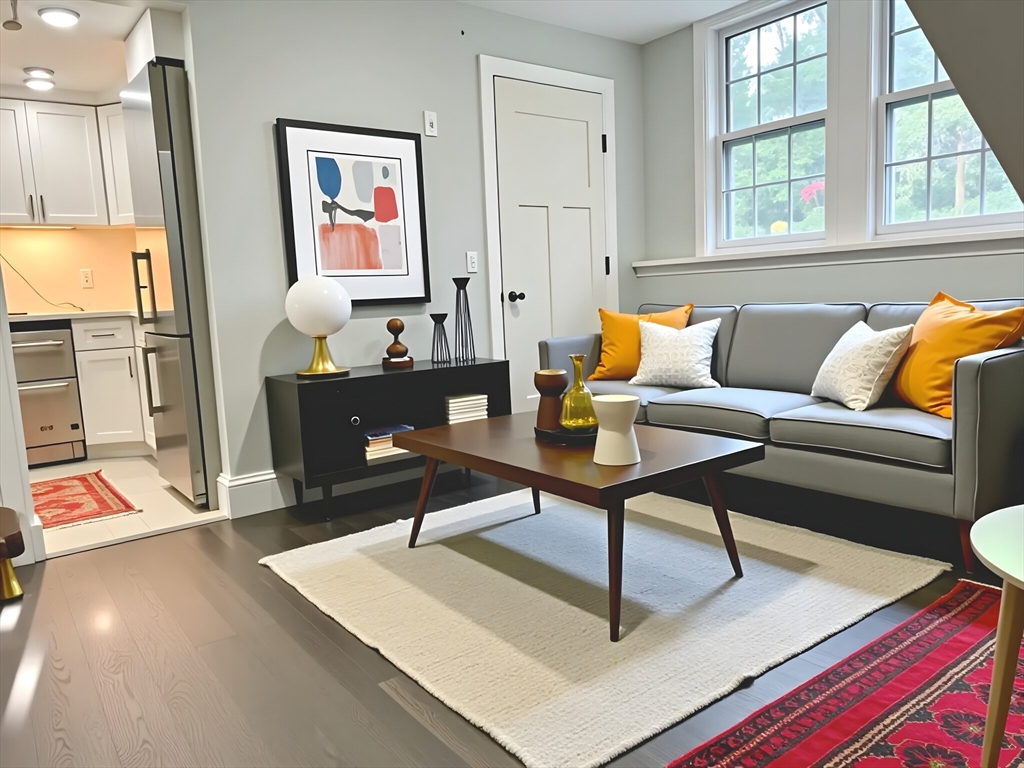 105 Charles Street, Unit 6 Boston, MA 02114 - Photo 7 of 7 a living room with furniture a wooden floor and next to a window