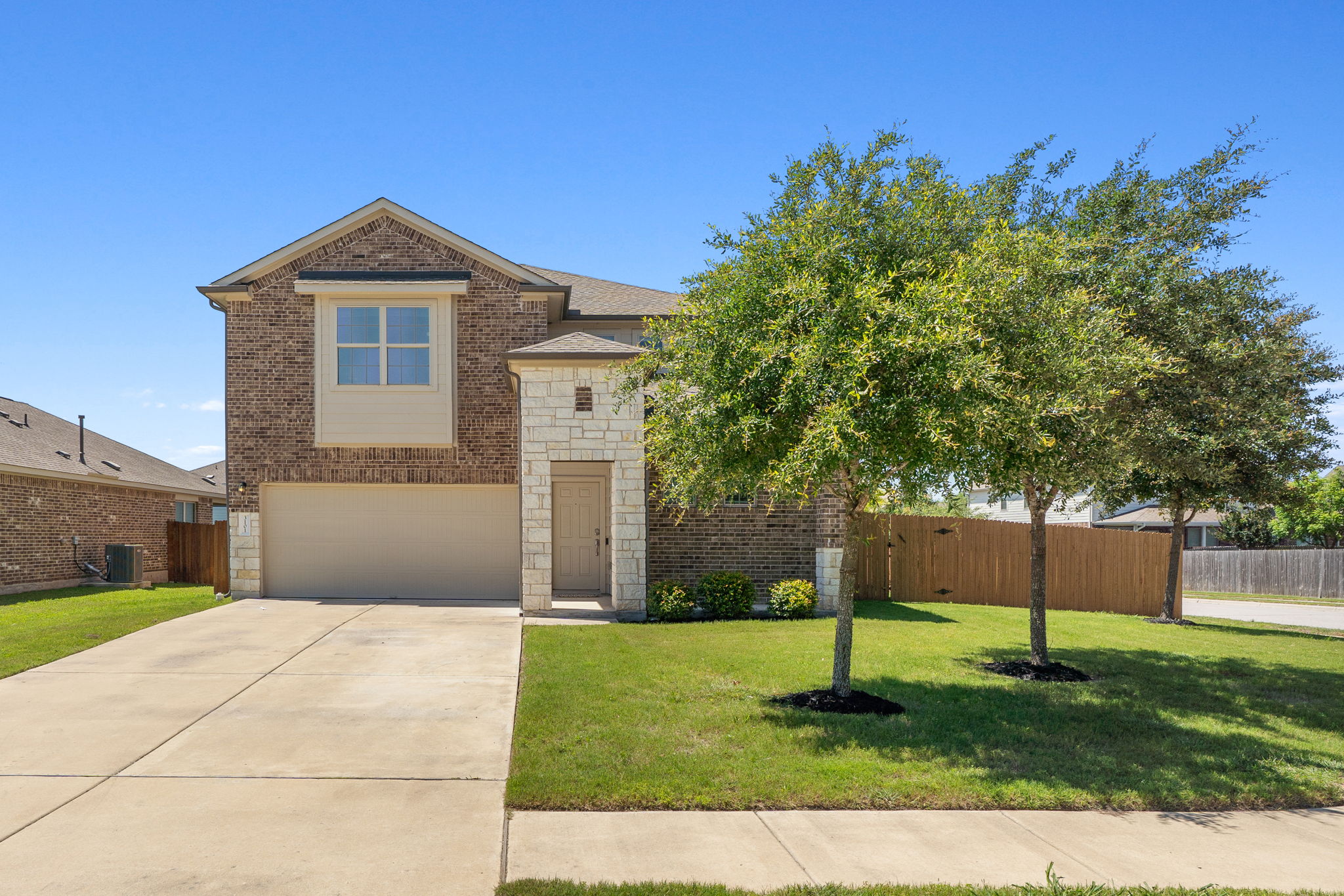3101 Fresh Spring Road Pflugerville, TX 78660 - Photo 1 of 39 A handsome brick and light stone facade welcomes guests with a covered porch, mature front yard trees, concrete driveway, and prominent corner location.