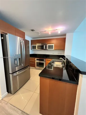 a kitchen with stainless steel appliances granite countertop a refrigerator and a sink