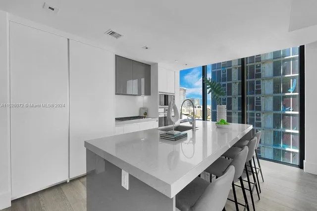 a view of kitchen island with stainless steel appliances furniture refrigerator and wooden floor