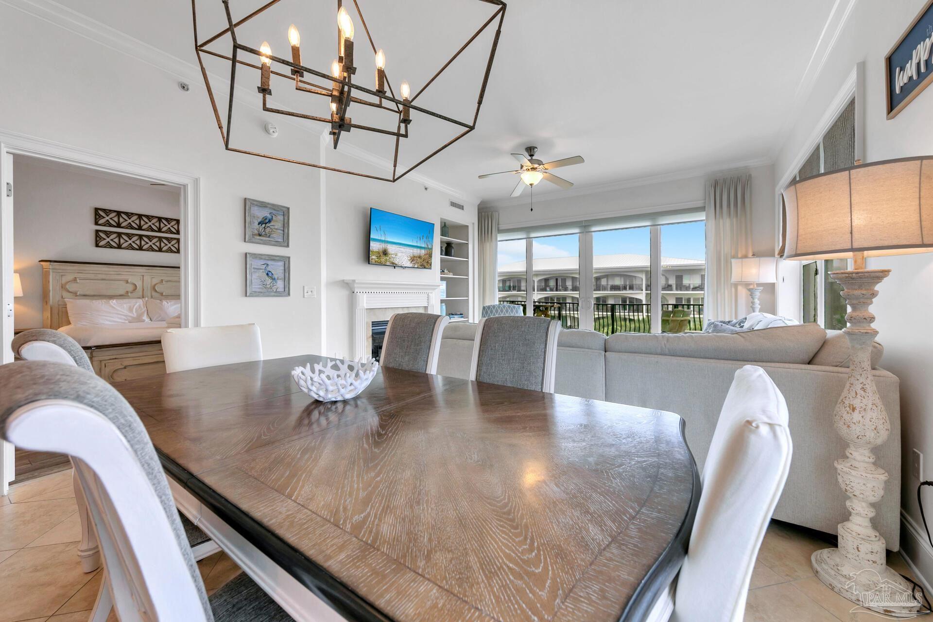 2421 West County Highway 30A, Unit G405 Santa Rosa Beach, FL 32459 - Photo 18 of 35 a view of a dining room with furniture a chandelier and wooden floor