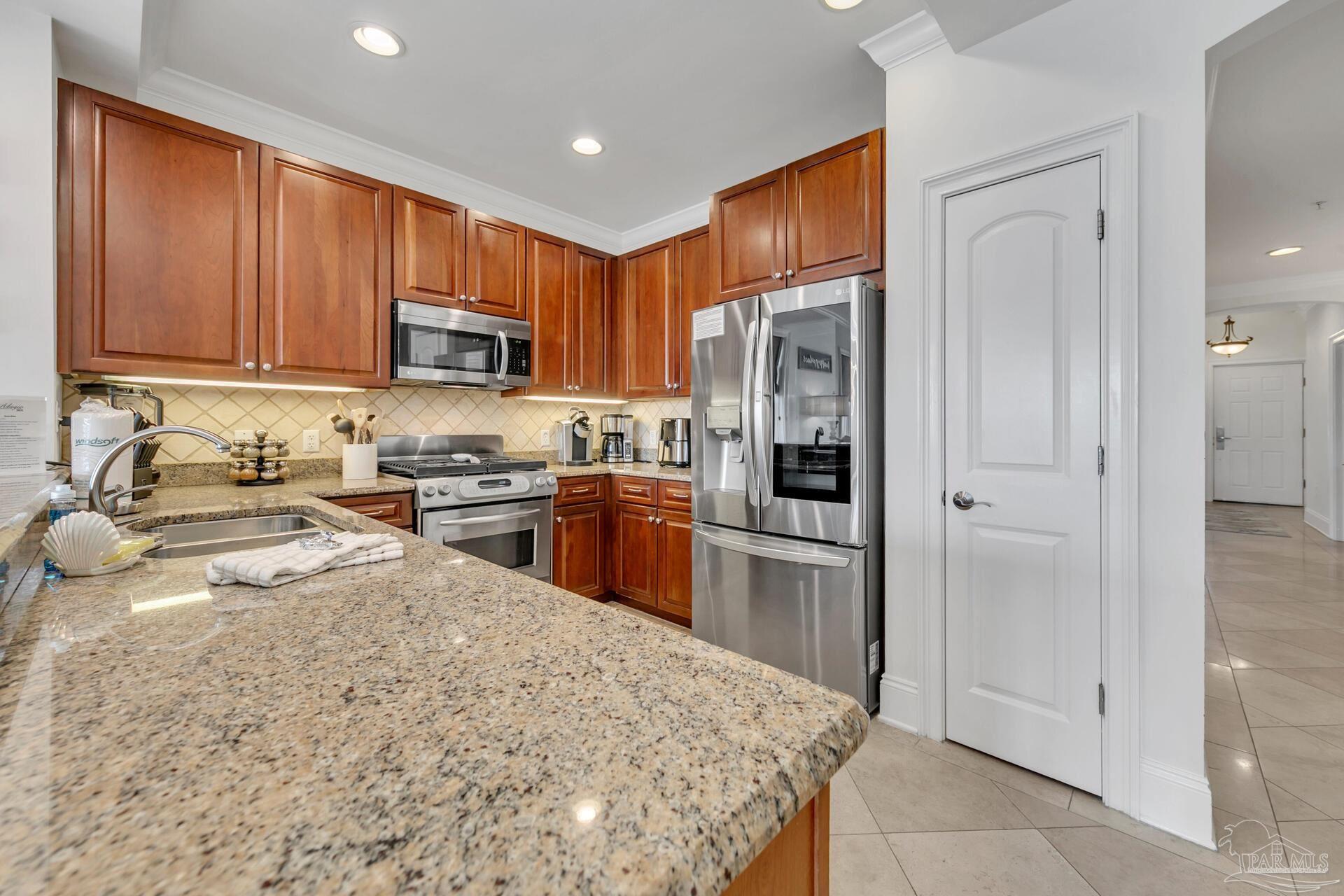 2421 West County Highway 30A, Unit G405 Santa Rosa Beach, FL 32459 - Photo 20 of 35 a kitchen with stainless steel appliances granite countertop a refrigerator stove and oven