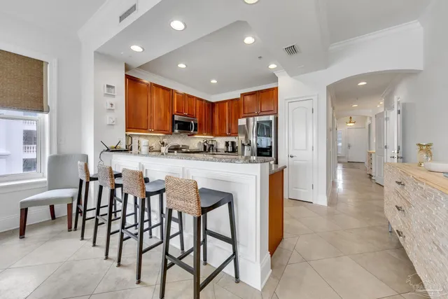 a kitchen with stainless steel appliances granite countertop a refrigerator and a sink