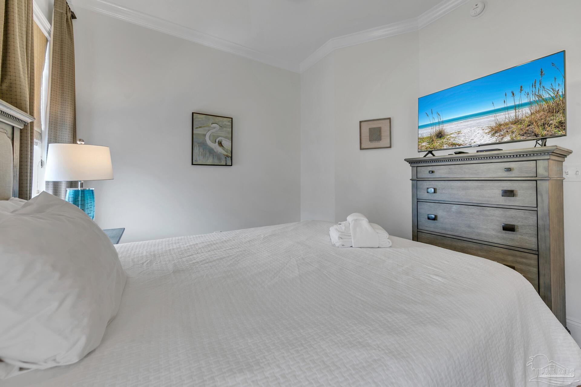 2421 West County Highway 30A, Unit G405 Santa Rosa Beach, FL 32459 - Photo 27 of 35 a bedroom with a bed and a lamp on dresser