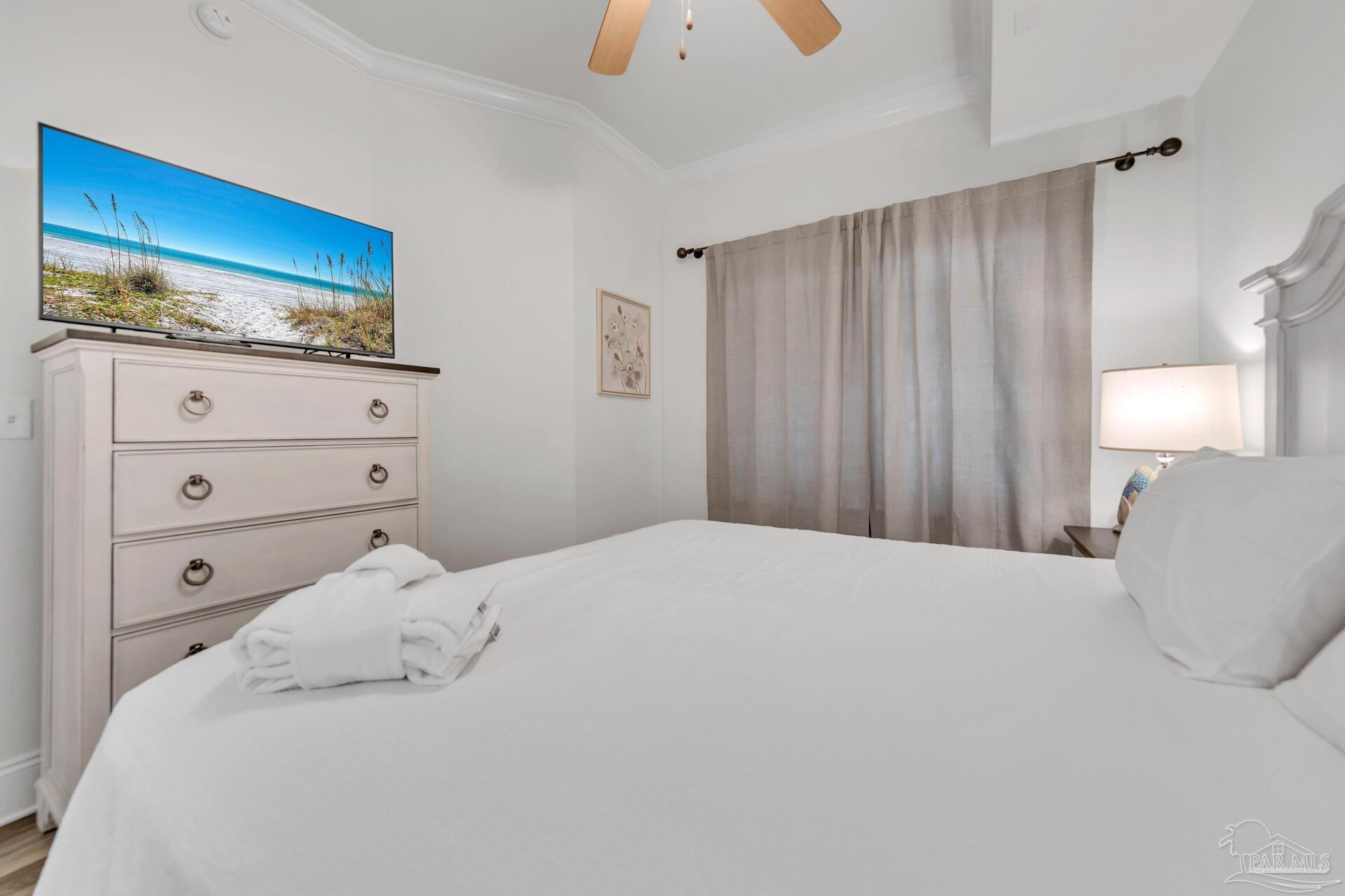 2421 West County Highway 30A, Unit G405 Santa Rosa Beach, FL 32459 - Photo 30 of 35 a bedroom with a bed and a lamp on dresser