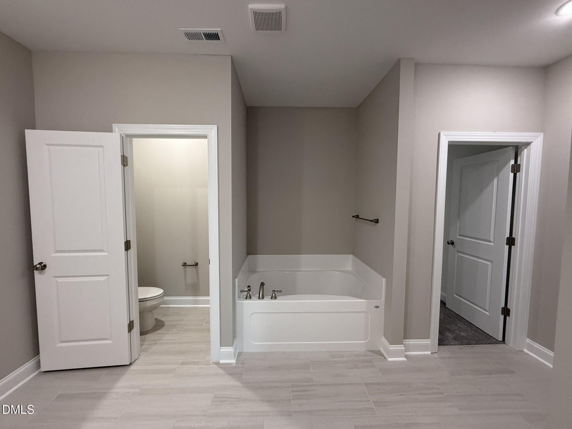 70 Hot Spgs Way Benson, NC 27504 - Photo 13 of 29 a bathroom with a granite countertop toilet a sink and bathtub