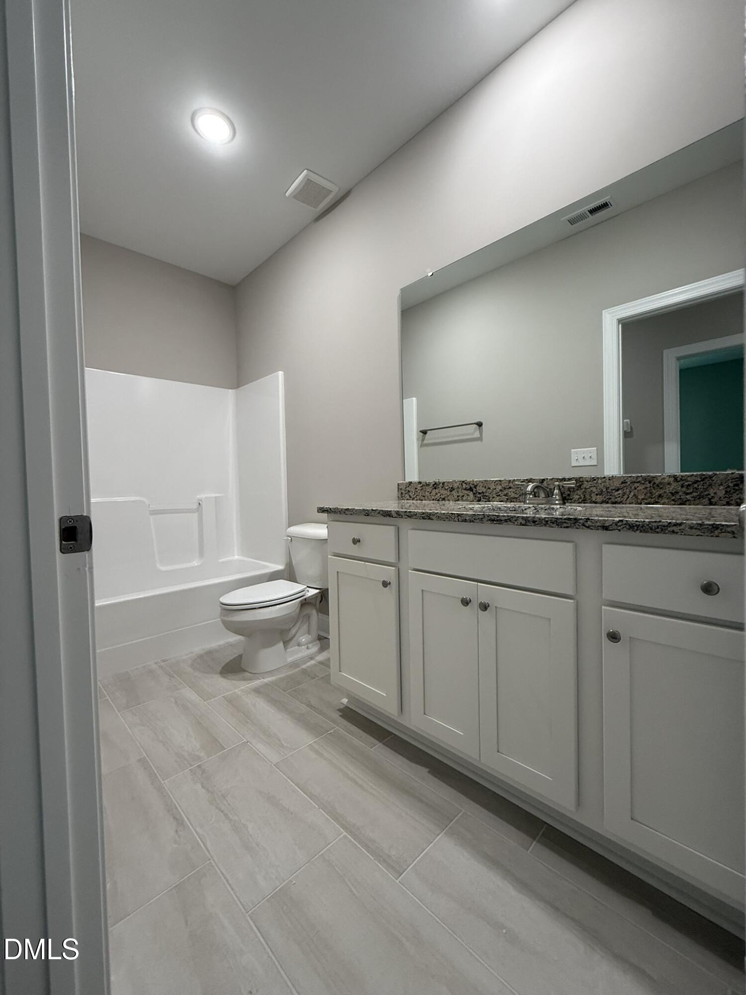 70 Hot Spgs Way Benson, NC 27504 - Photo 21 of 29 a spacious bathroom with a granite countertop sink and a mirror