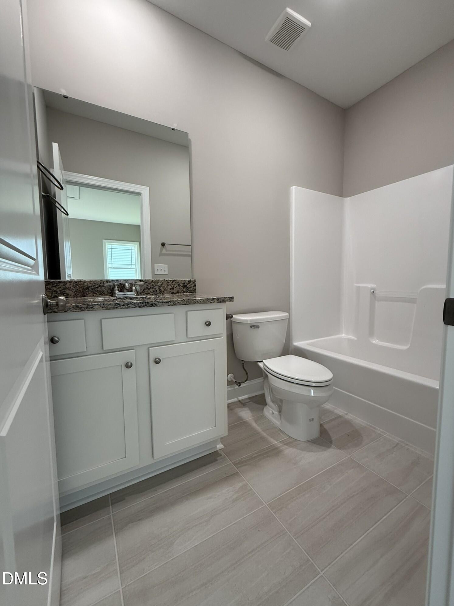 70 Hot Spgs Way Benson, NC 27504 - Photo 25 of 29 a bathroom with a granite countertop sink a toilet and a mirror