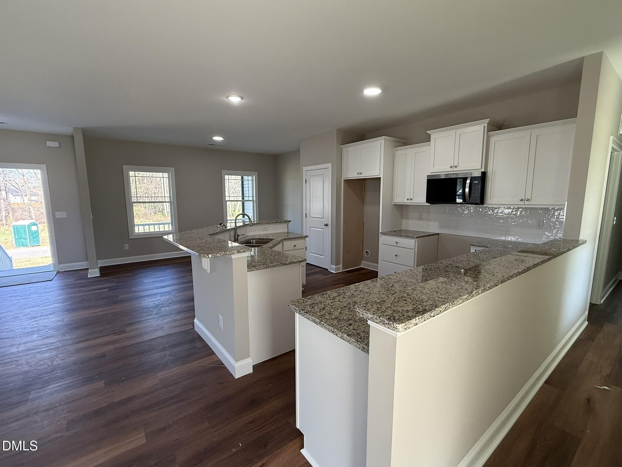 70 Hot Spgs Way Benson, NC 27504 - Photo 8 of 29 a kitchen with stainless steel appliances granite countertop a sink a stove and a wooden floors