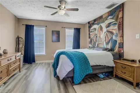 a spacious bedroom with a bed and a dresser