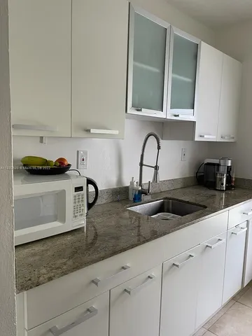 a kitchen with appliances a sink and cabinets
