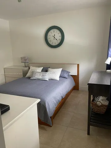 a bedroom with a bed and a lamp on dresser