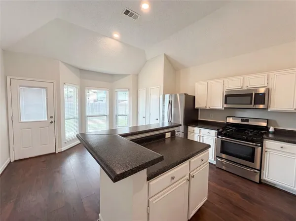 a kitchen with stainless steel appliances granite countertop a sink a stove and microwave