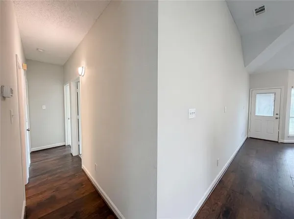 a view of a hallway with wooden floor