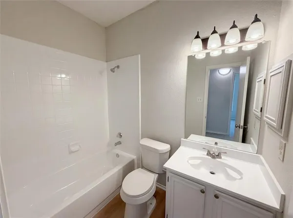 a bathroom with a toilet a sink and mirror