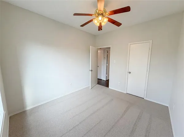an empty room with chandelier fan