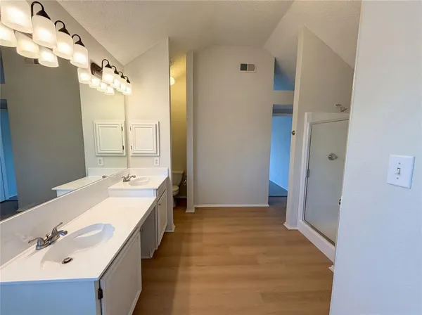 a spacious bathroom with a double vanity sink mirror and shower