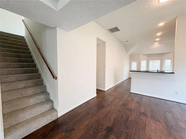 a view of a hallway with wooden floor and staircase