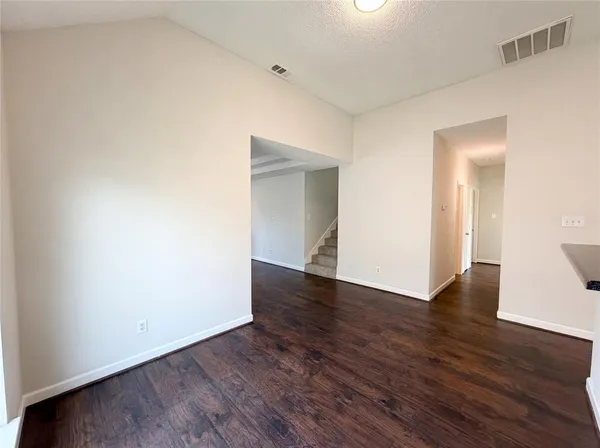 a view of an empty room with wooden floor and closet