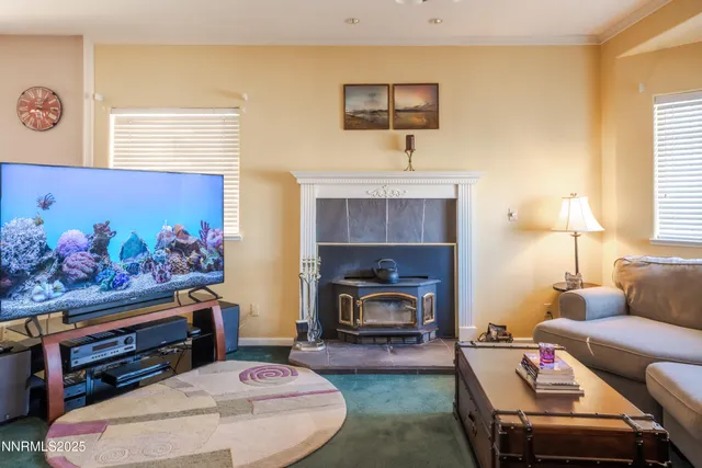 a living room with furniture fireplace and a large window