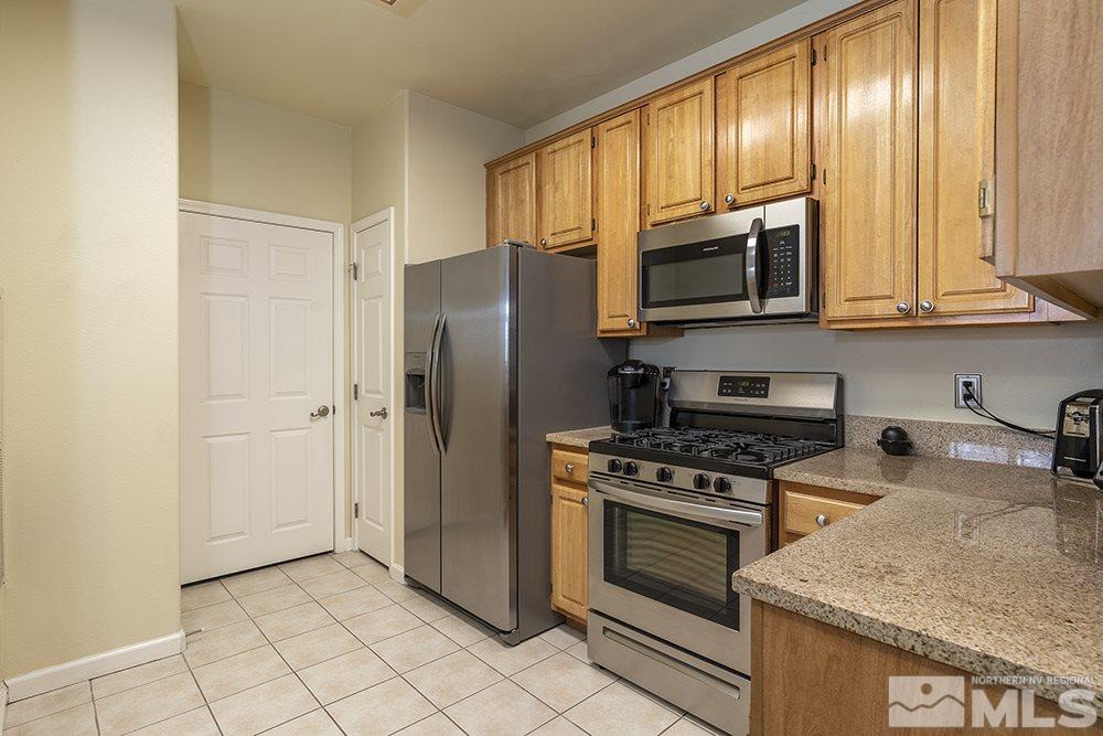 900 South, Unit 1424 Reno, NV 89521 - Photo 7 of 24 a kitchen with granite countertop a refrigerator stove and microwave