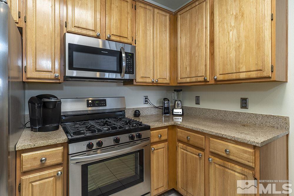 900 South, Unit 1424 Reno, NV 89521 - Photo 8 of 24 a kitchen with stainless steel appliances granite countertop white cabinets and a stove top oven