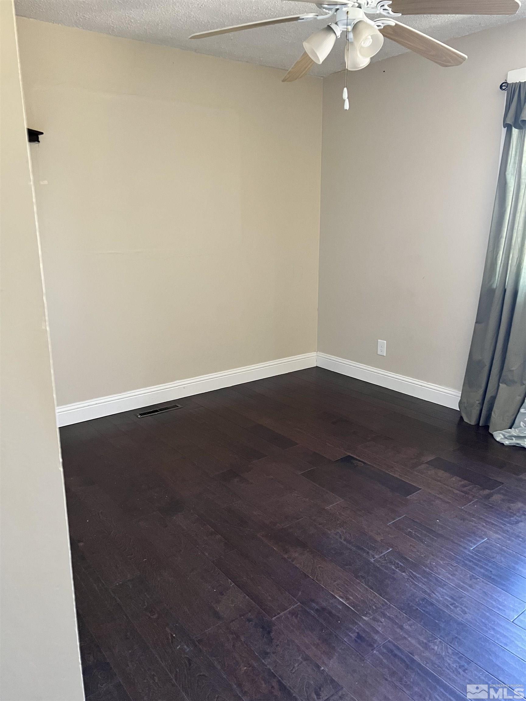 908 Lester Avenue Reno, NV 89502 - Photo 14 of 35 an empty room with wooden floor and fan