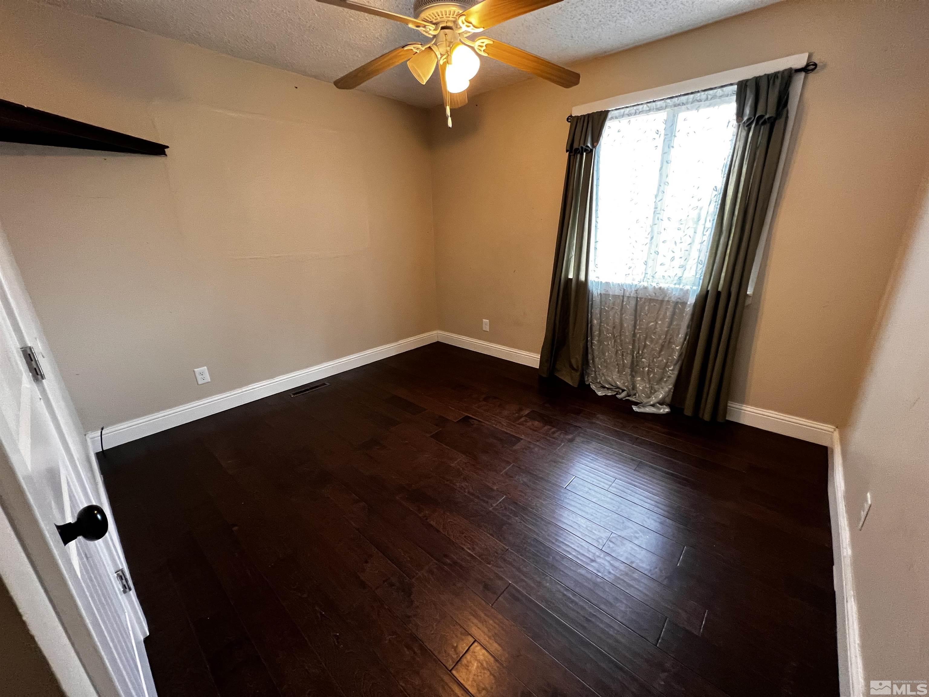 908 Lester Avenue Reno, NV 89502 - Photo 15 of 35 an empty room with wooden floor and windows