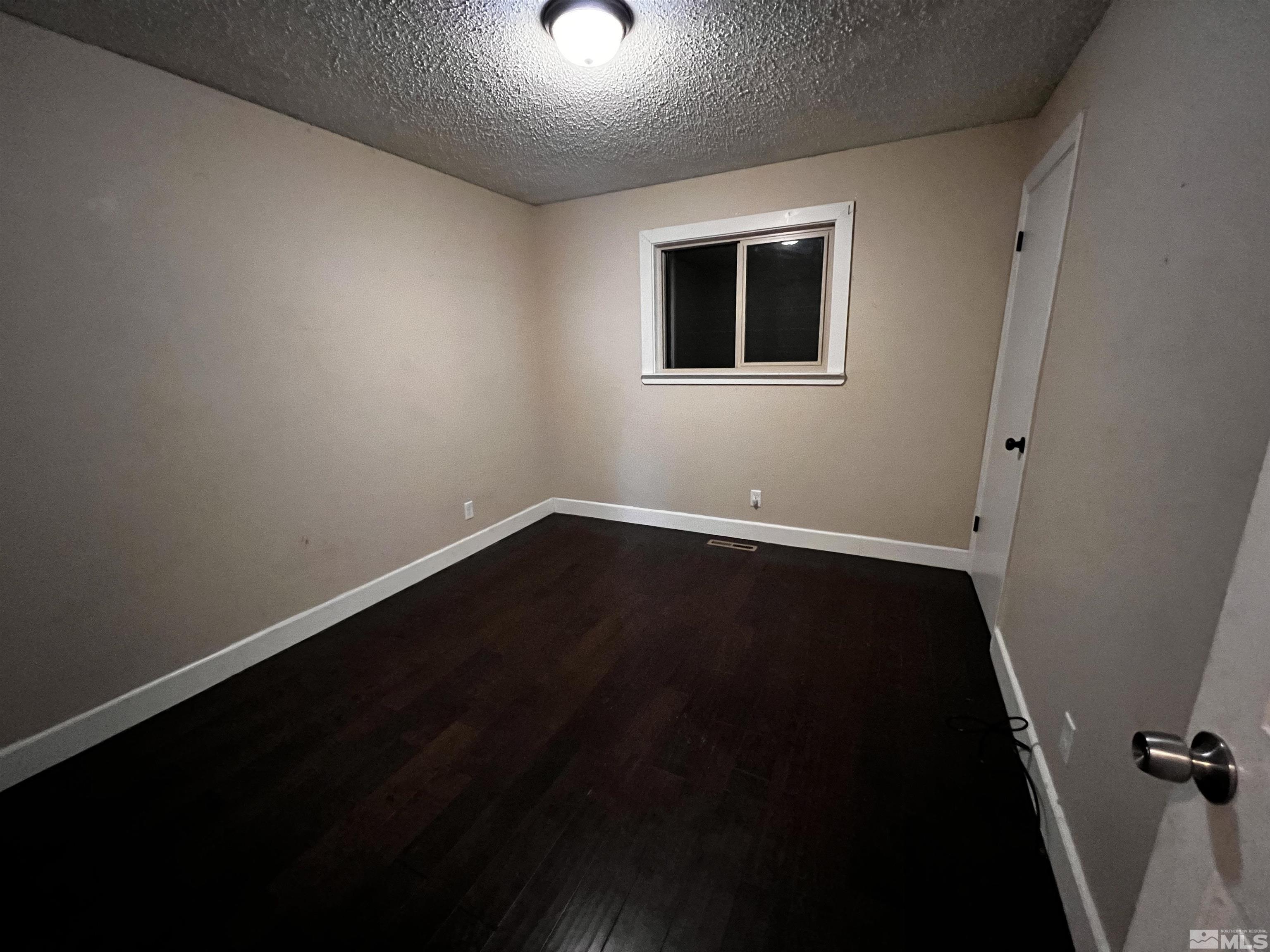 908 Lester Avenue Reno, NV 89502 - Photo 16 of 35 a view of an empty room with wooden floor and a window