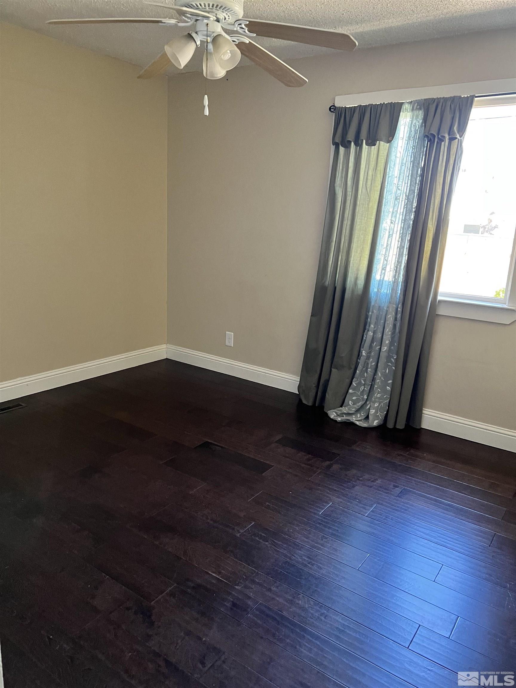 908 Lester Avenue Reno, NV 89502 - Photo 17 of 35 an empty room with wooden floor and window