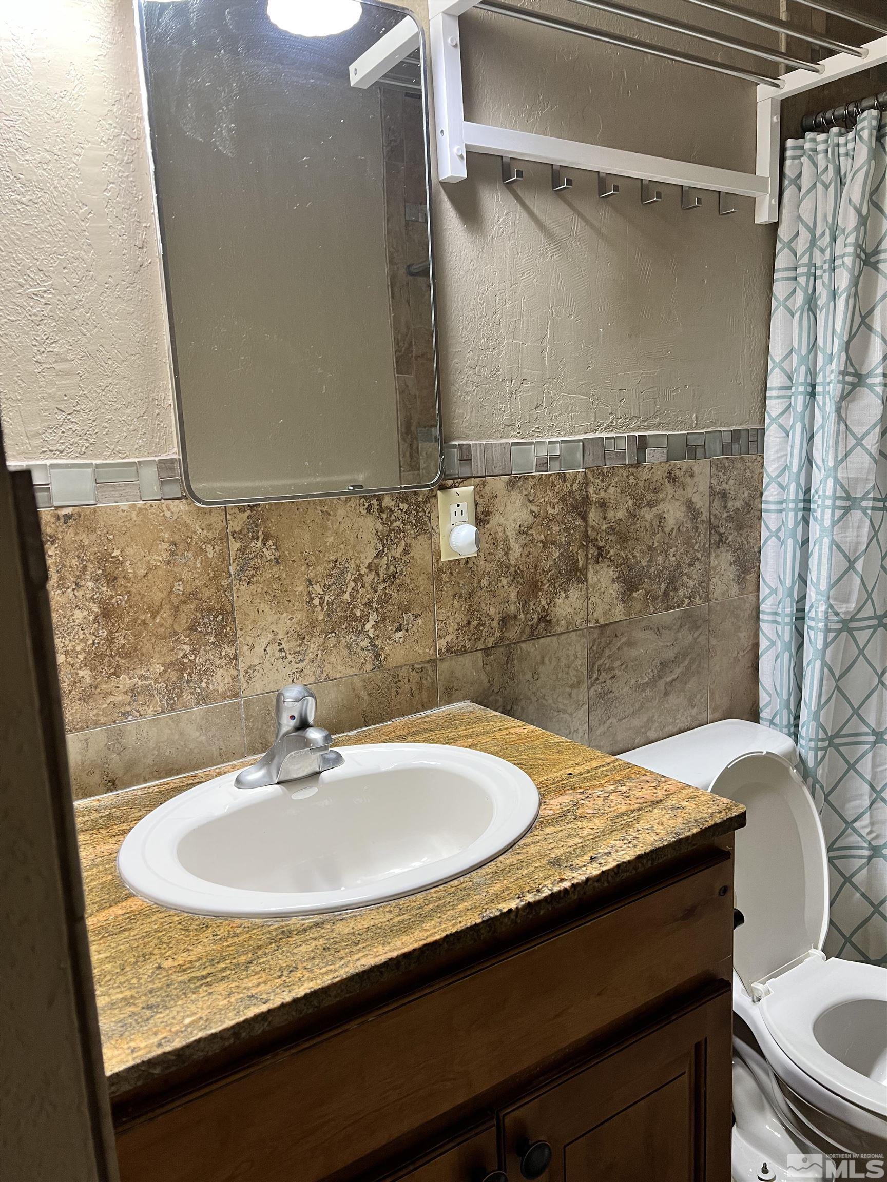 908 Lester Avenue Reno, NV 89502 - Photo 24 of 35 a bathroom with a granite countertop sink and a toilet