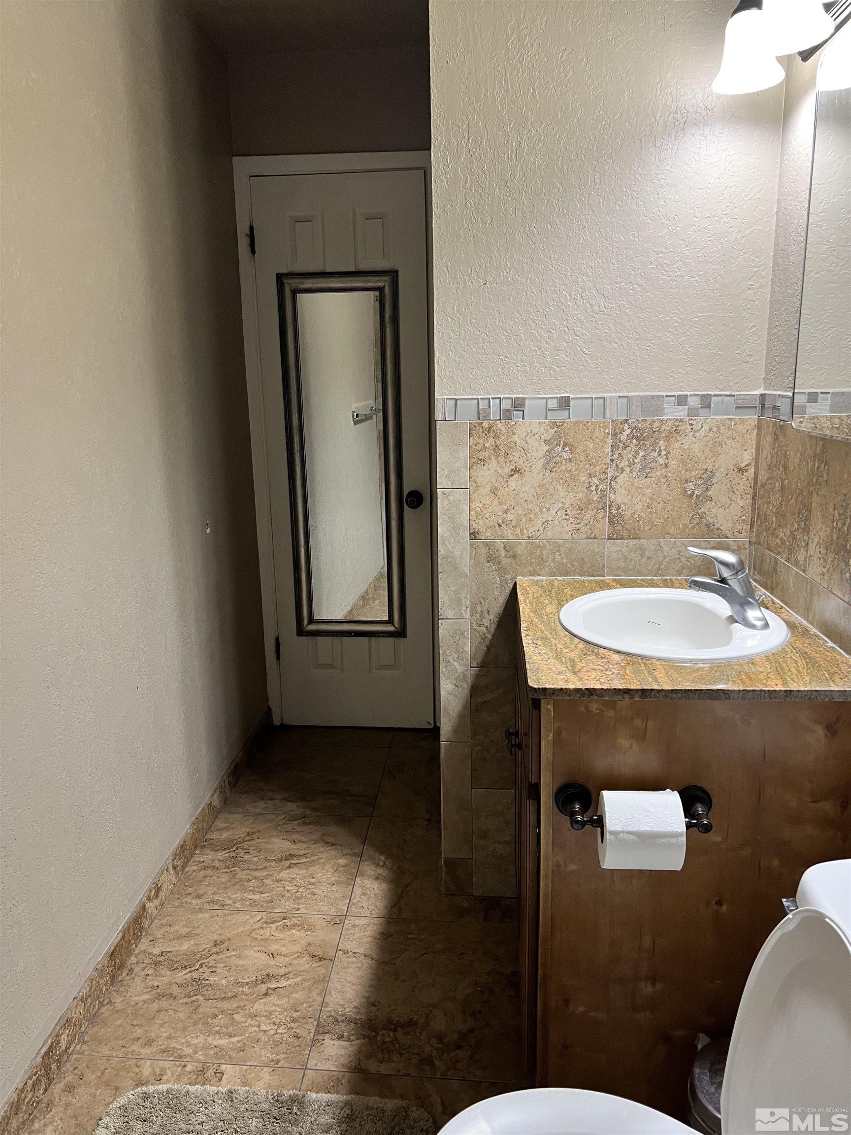 908 Lester Avenue Reno, NV 89502 - Photo 26 of 35 a bathroom with a sink a toilet and mirror