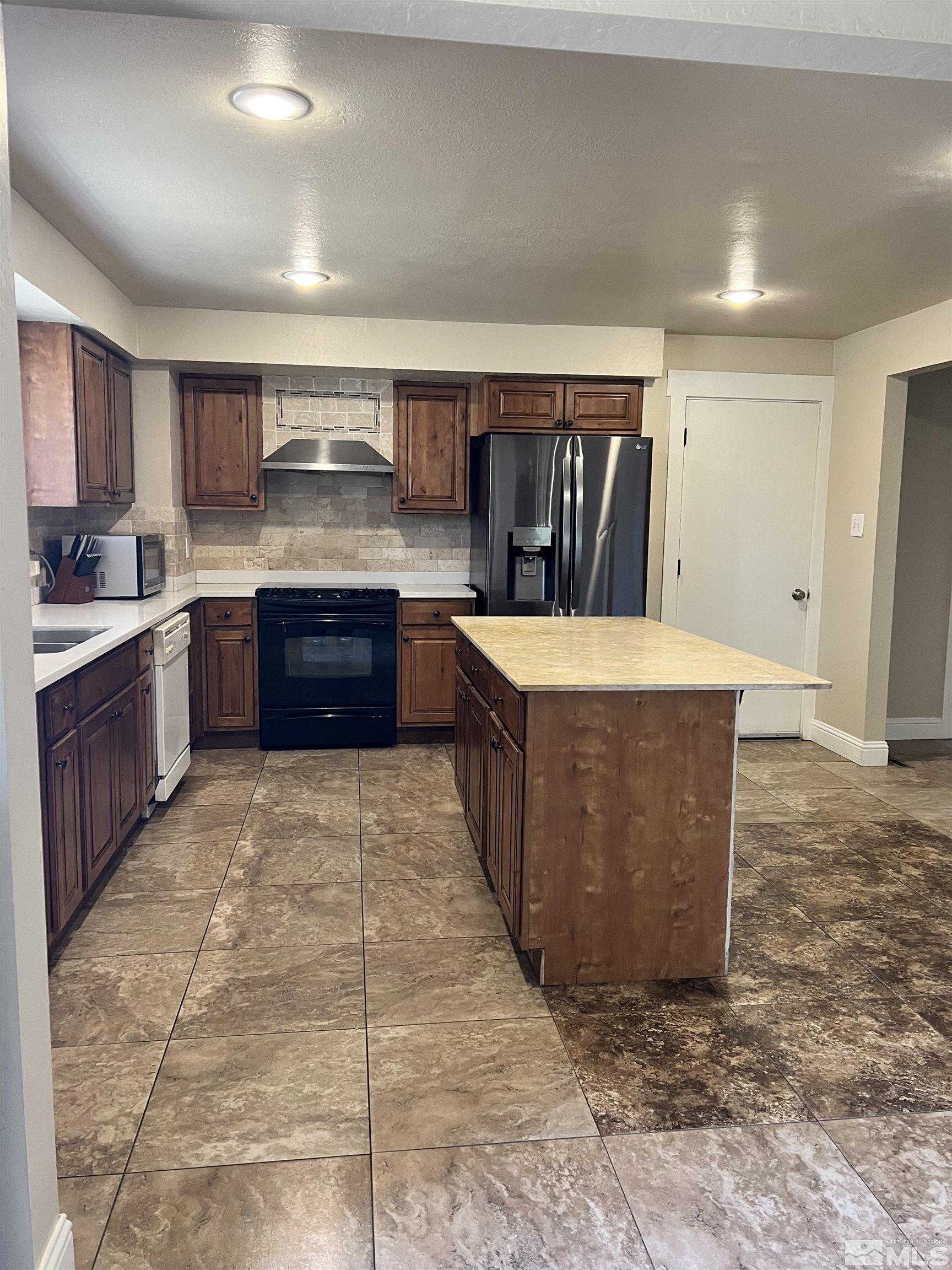 908 Lester Avenue Reno, NV 89502 - Photo 3 of 35 a large kitchen with kitchen island granite countertop a sink a counter top space and cabinets