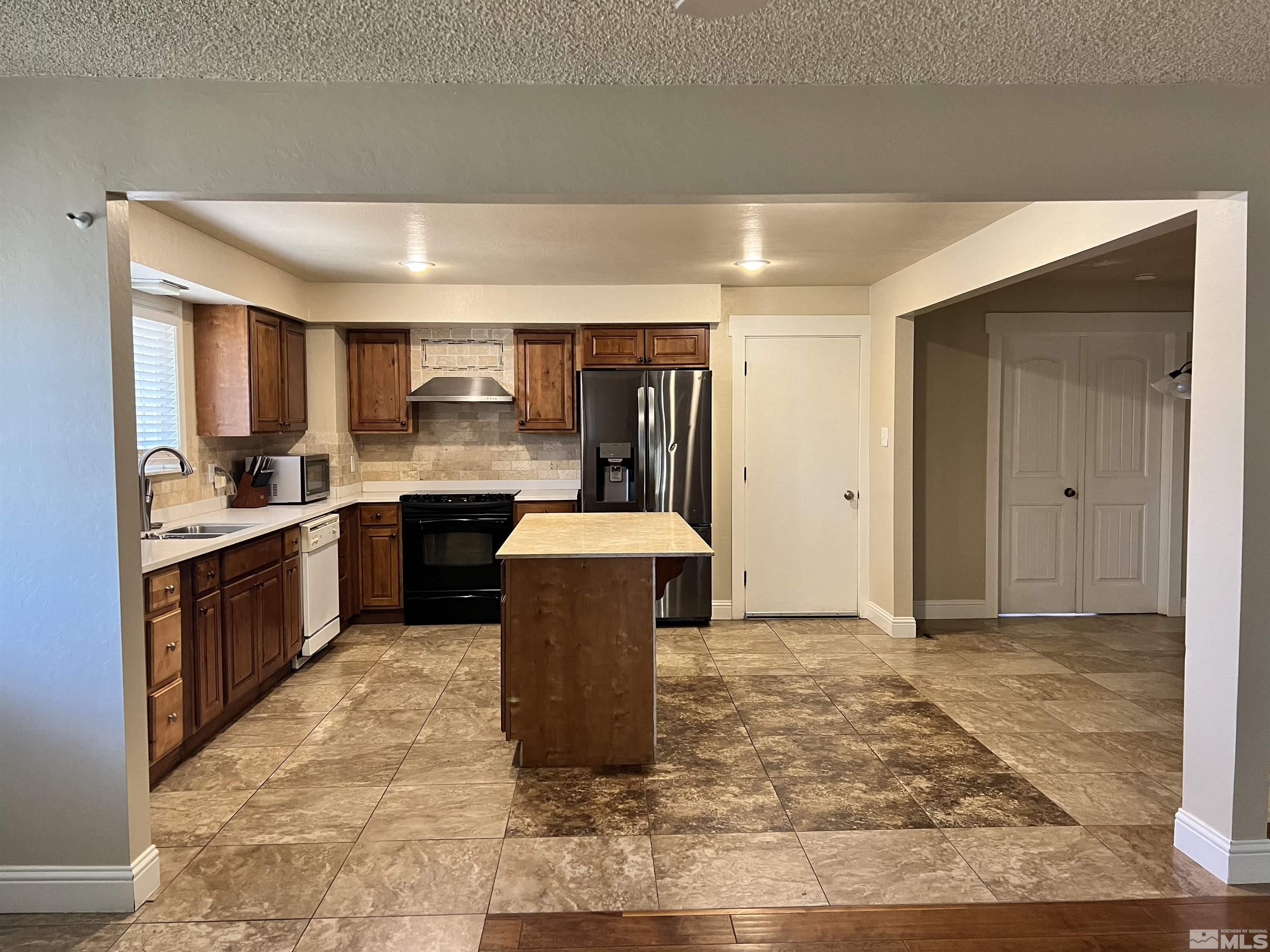 908 Lester Avenue Reno, NV 89502 - Photo 4 of 35 a kitchen with granite countertop a sink cabinets and stainless steel appliances