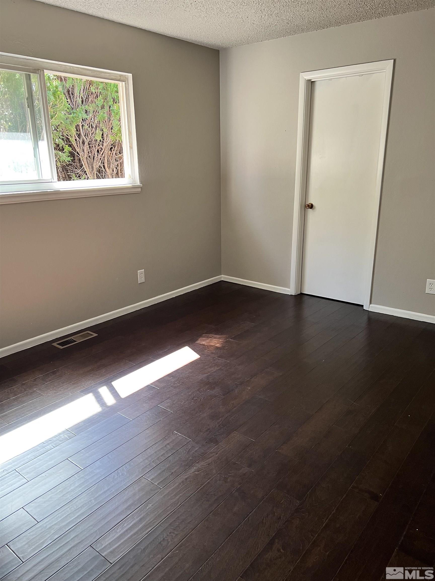 908 Lester Avenue Reno, NV 89502 - Photo 8 of 35 an empty room with wooden floor and windows