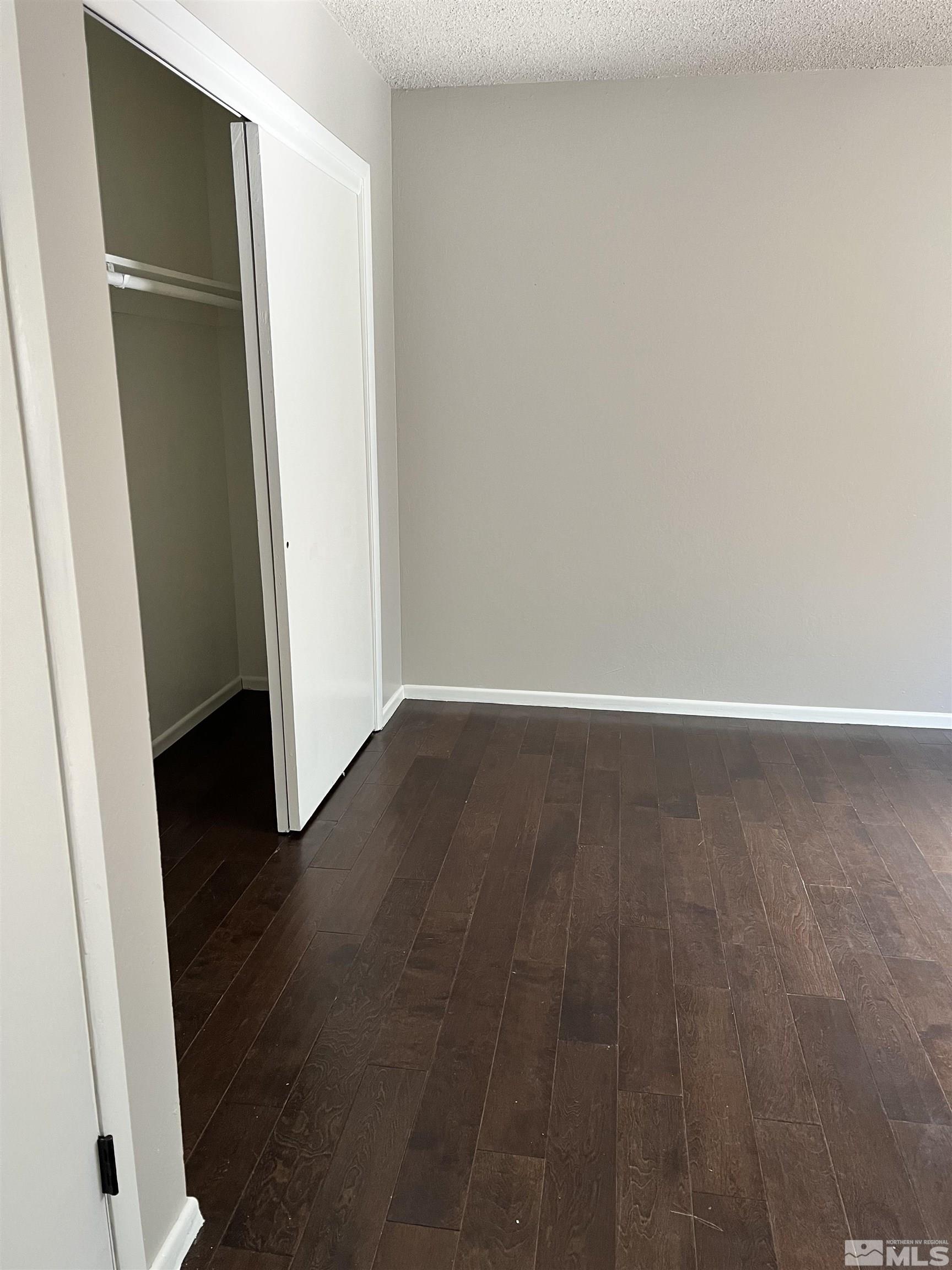 908 Lester Avenue Reno, NV 89502 - Photo 9 of 35 an empty room with wooden floor and door