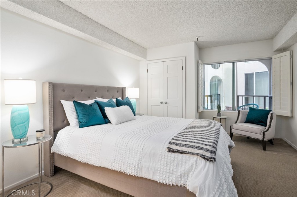 565 Esplanade, Unit 104 Redondo Beach, CA 90277 - Photo 23 of 42 a bed room with a bed and a couch