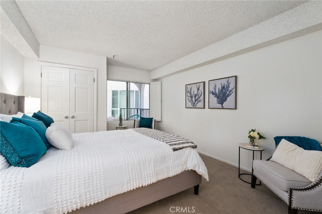 565 Esplanade, Unit 104 Redondo Beach, CA 90277 - Photo 26 of 42 a bedroom with a bed and a couch