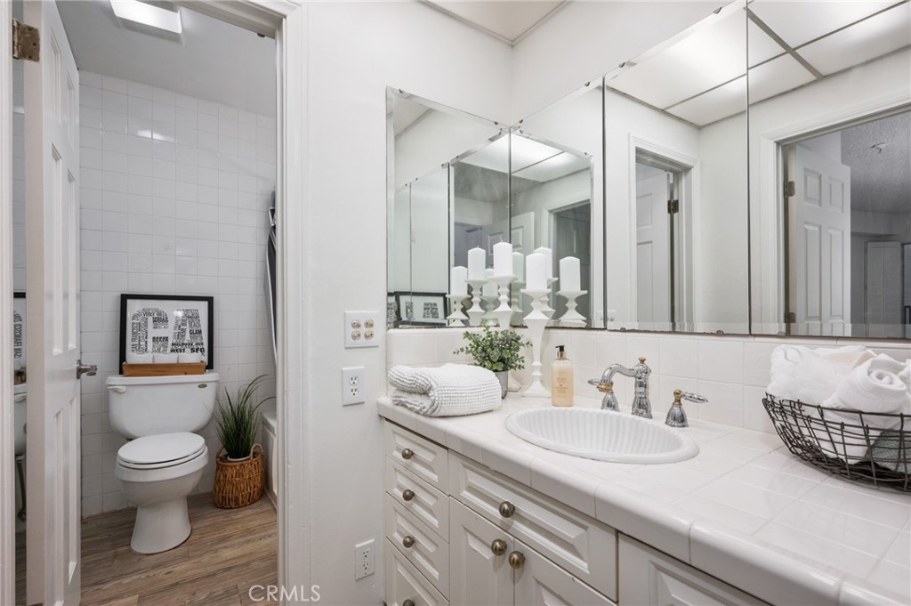 565 Esplanade, Unit 104 Redondo Beach, CA 90277 - Photo 30 of 42 a bathroom with a granite countertop sink mirror and toilet
