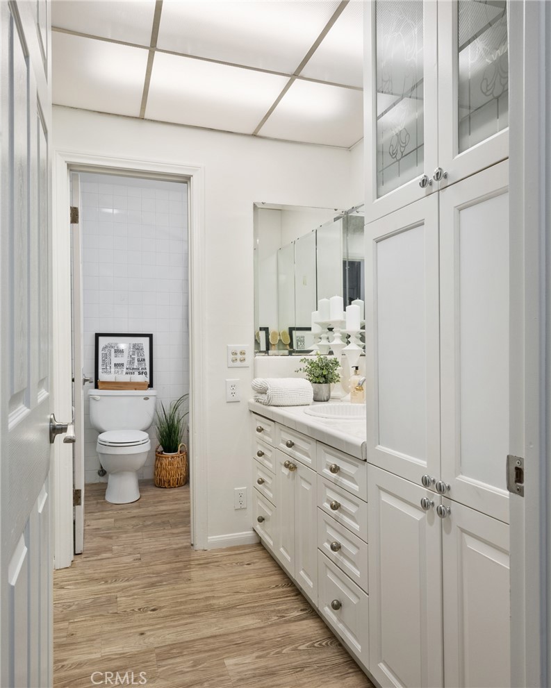 565 Esplanade, Unit 104 Redondo Beach, CA 90277 - Photo 31 of 42 a bathroom with a granite countertop sink mirror vanity and toilet