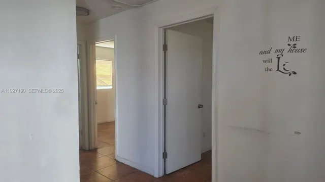 a view of a hallway with closet and a mirror