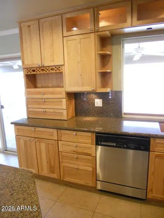 a kitchen with stainless steel appliances granite countertop a sink a stove a refrigerator cabinets and chairs
