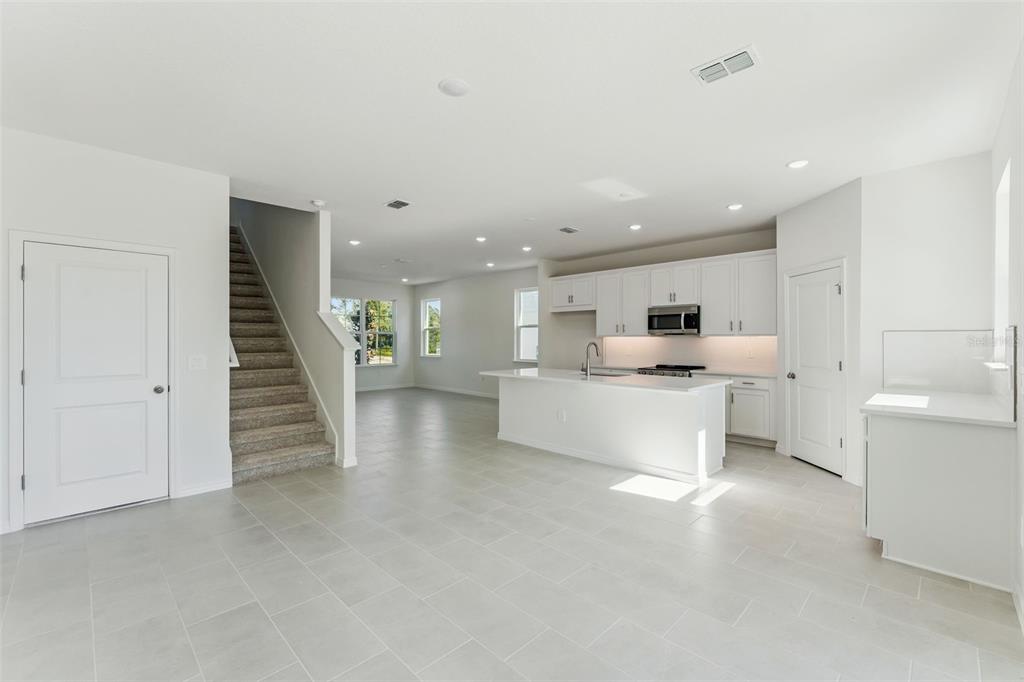 4295 Darby Court Eustis, FL 32736 - Photo 11 of 25 a large white kitchen with white cabinets and a sink