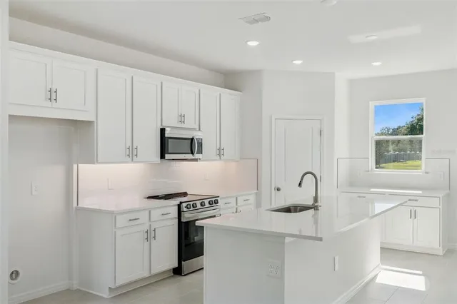 a kitchen with stainless steel appliances granite countertop a sink and a stove