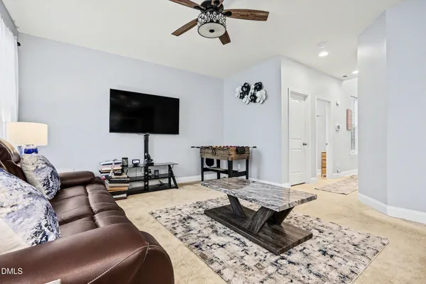 a kitchen with stainless steel appliances granite countertop a dining table chairs refrigerator and sink