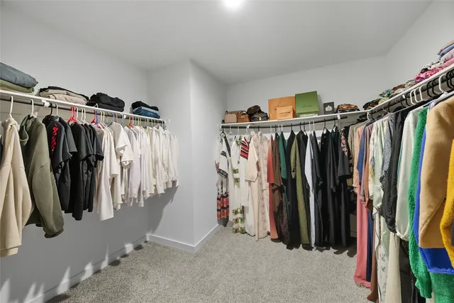 a view of walk in closet with clothes and shoes